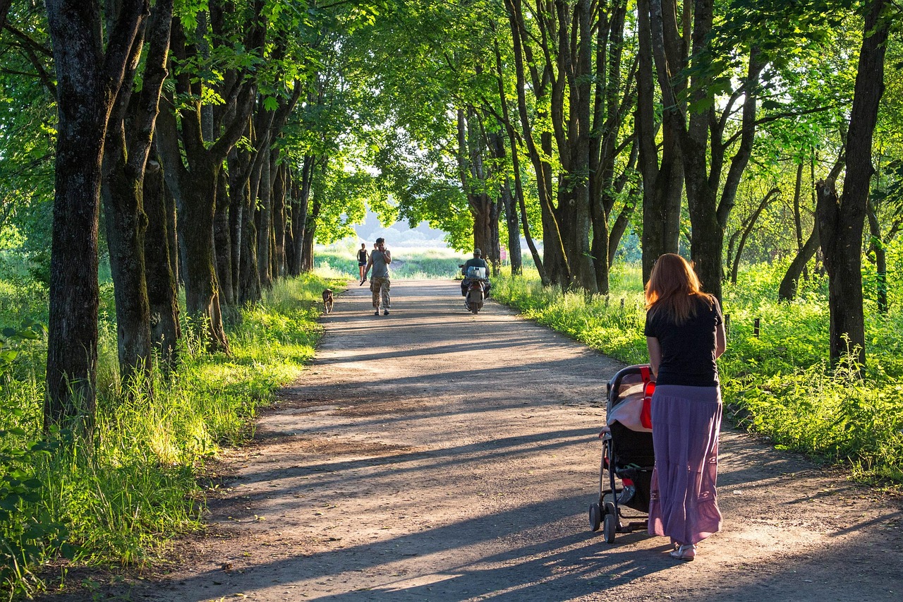 Famiglia con passeggini su un sentiero facile immerso nella natura.