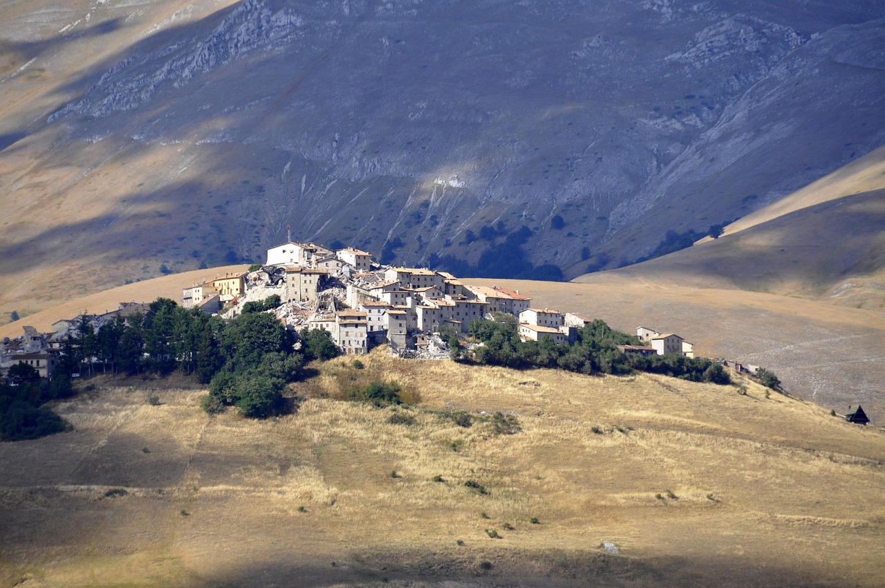 Due innamorati passeggiano tra colline verdi e borghi storici al tramonto.