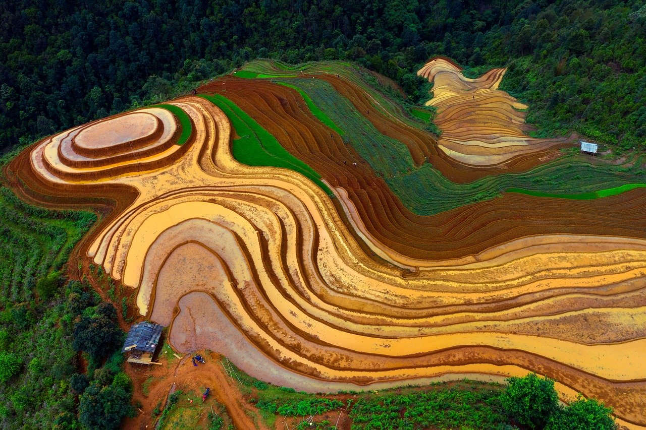 Panorama di un borgo pittoresco circondato da colline e natura, con colori vividi e suggestivi.