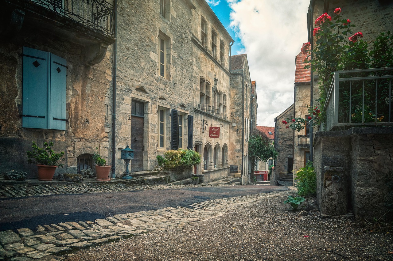 Vista panoramica di un suggestivo borgo storico con stradine acciottolate e antiche abitazioni.