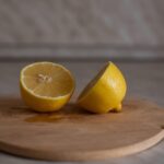 Immagine di acido citrico in polvere con limoni freschi e prodotti per la pulizia domestica.