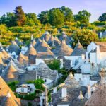 Panorama autunnale di un borgo italiano famoso per il tartufo, con alberi dai colori caldi e strade acciottolate.