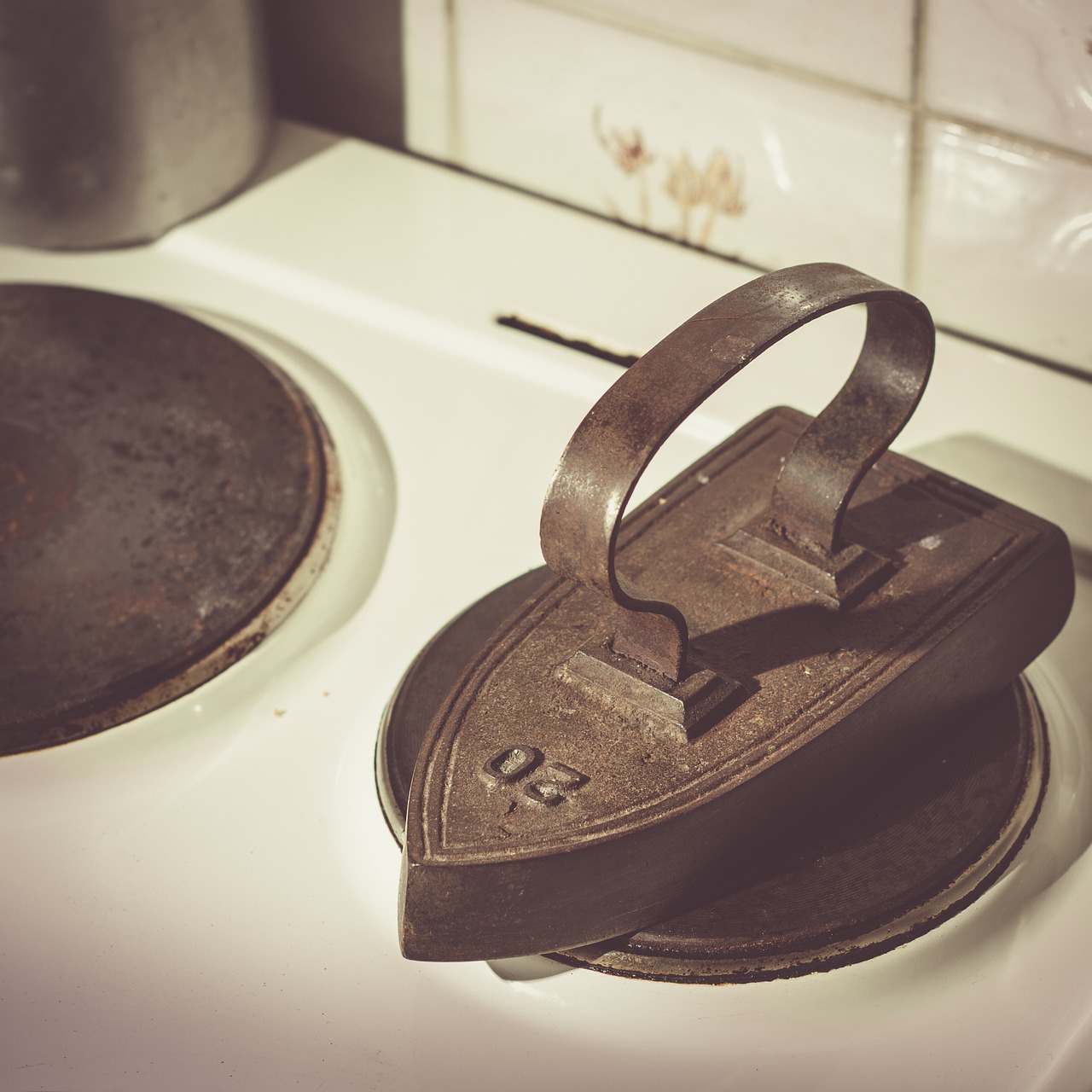 Ferro da stiro con vapore, vicino a una bottiglia di aceto per rimuovere il calcare.