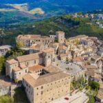 Vista panoramica del borgo laziale, con case in pietra e paesaggio verde, popolare sui social media.