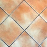 Fughe delle piastrelle pulite e bianche dopo il trattamento descritto nell'articolo.