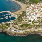 Camper parcheggiati in una pittoresca area di sosta italiana circondata da paesaggi mozzafiato.