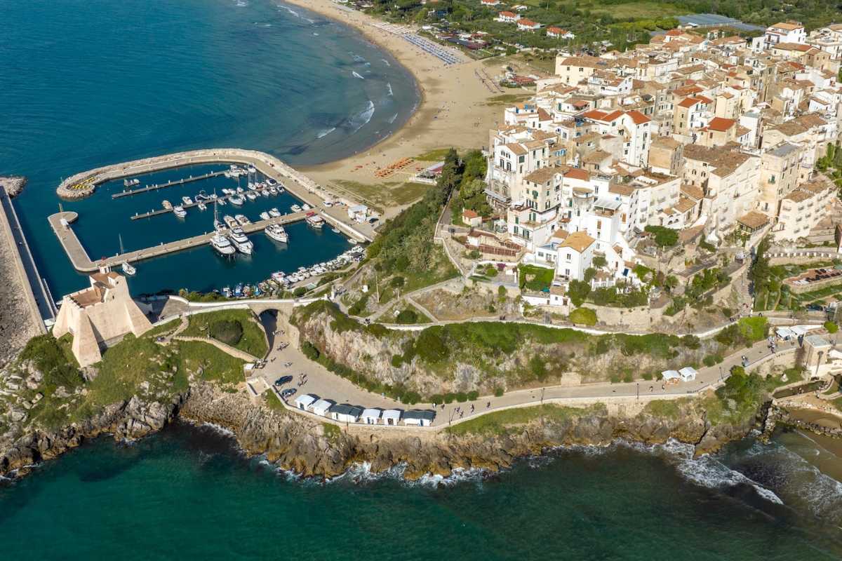 Camper parcheggiati in una pittoresca area di sosta italiana circondata da paesaggi mozzafiato.