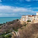 Ufficio domestico in un borgo italiano, con vista su paesaggio rurale e elementi di lavoro remoto.