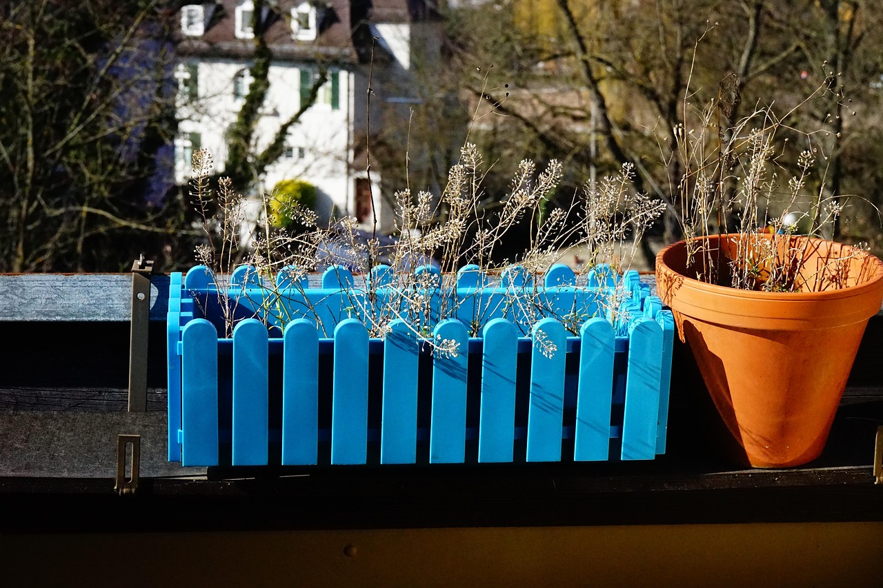 Immagine di un balcone con diverse piante verdi e fiorite pronte per la primavera.