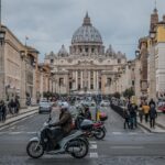 Panorama di Roma con Colosseo e Fori Imperiali al tramonto, simboli della città eterna.