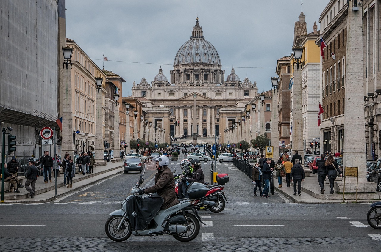 Panorama di Roma con Colosseo e Fori Imperiali al tramonto, simboli della città eterna.