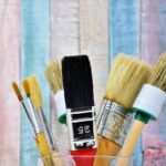 Immagine di un uomo che dipinge una parete di casa, evidenziando gli errori comuni nel fai-da-te.