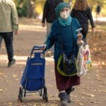 Persone anziane sorridenti mentre leggono un documento informativo sulle nuove esenzioni per gli over 65.